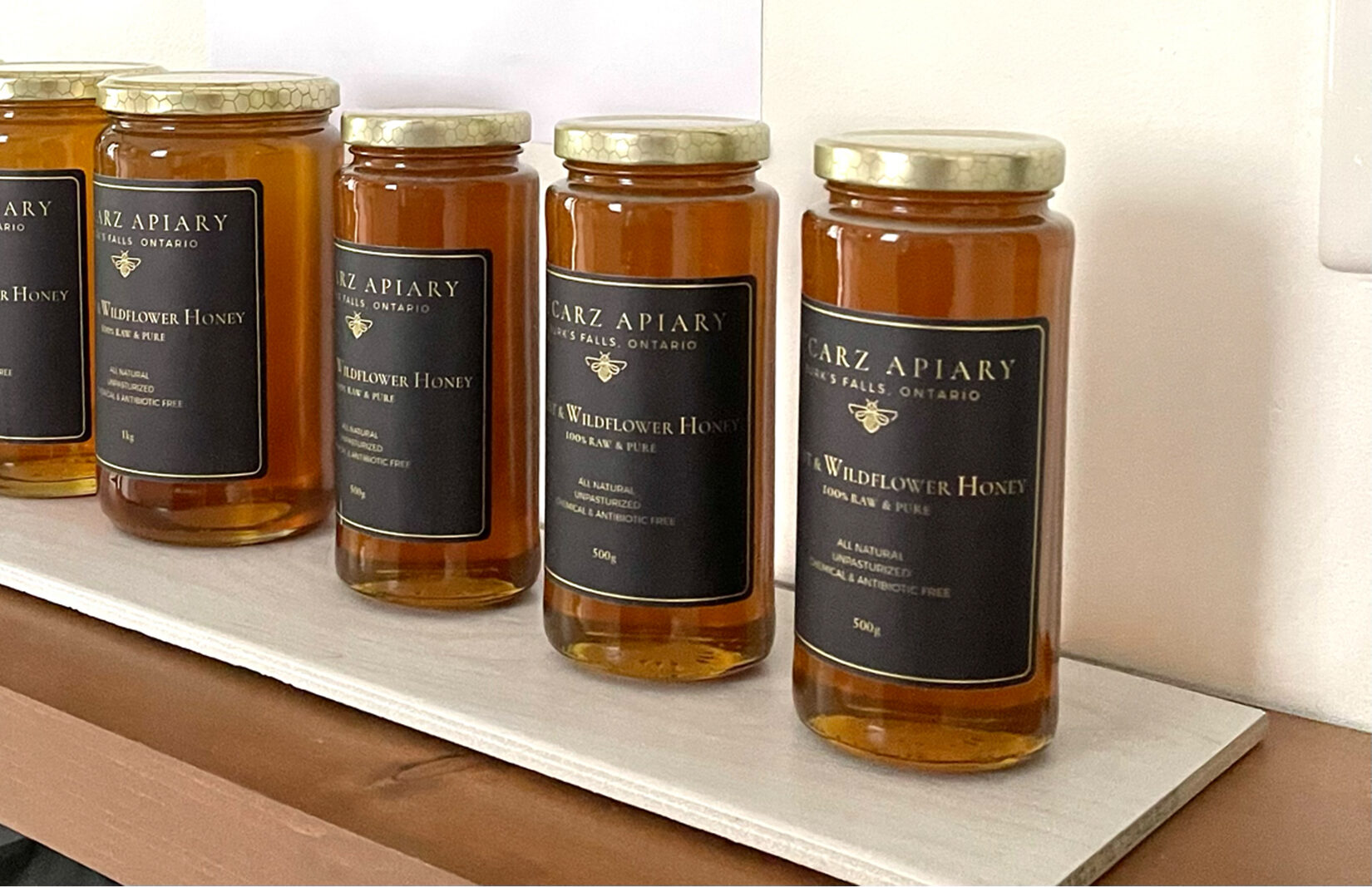 A row of Lucarz Apiary honey jars in 500g and 1kg sizes